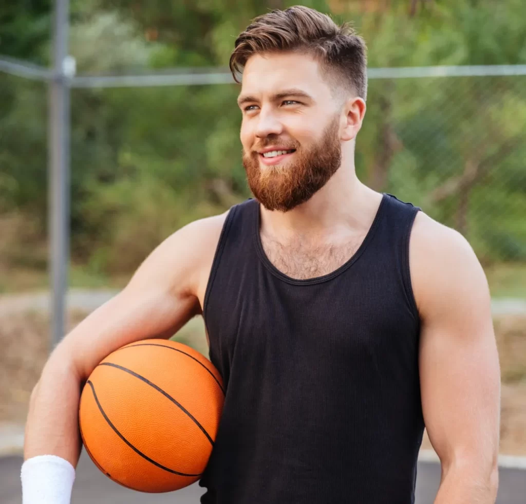 cheerful happy basketball player standing with bal utc
