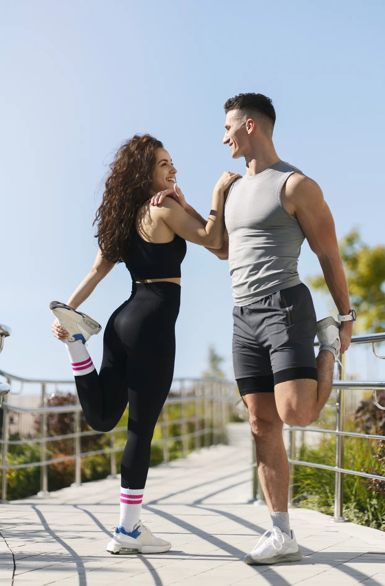 couple stretching outdoors before morning run utc