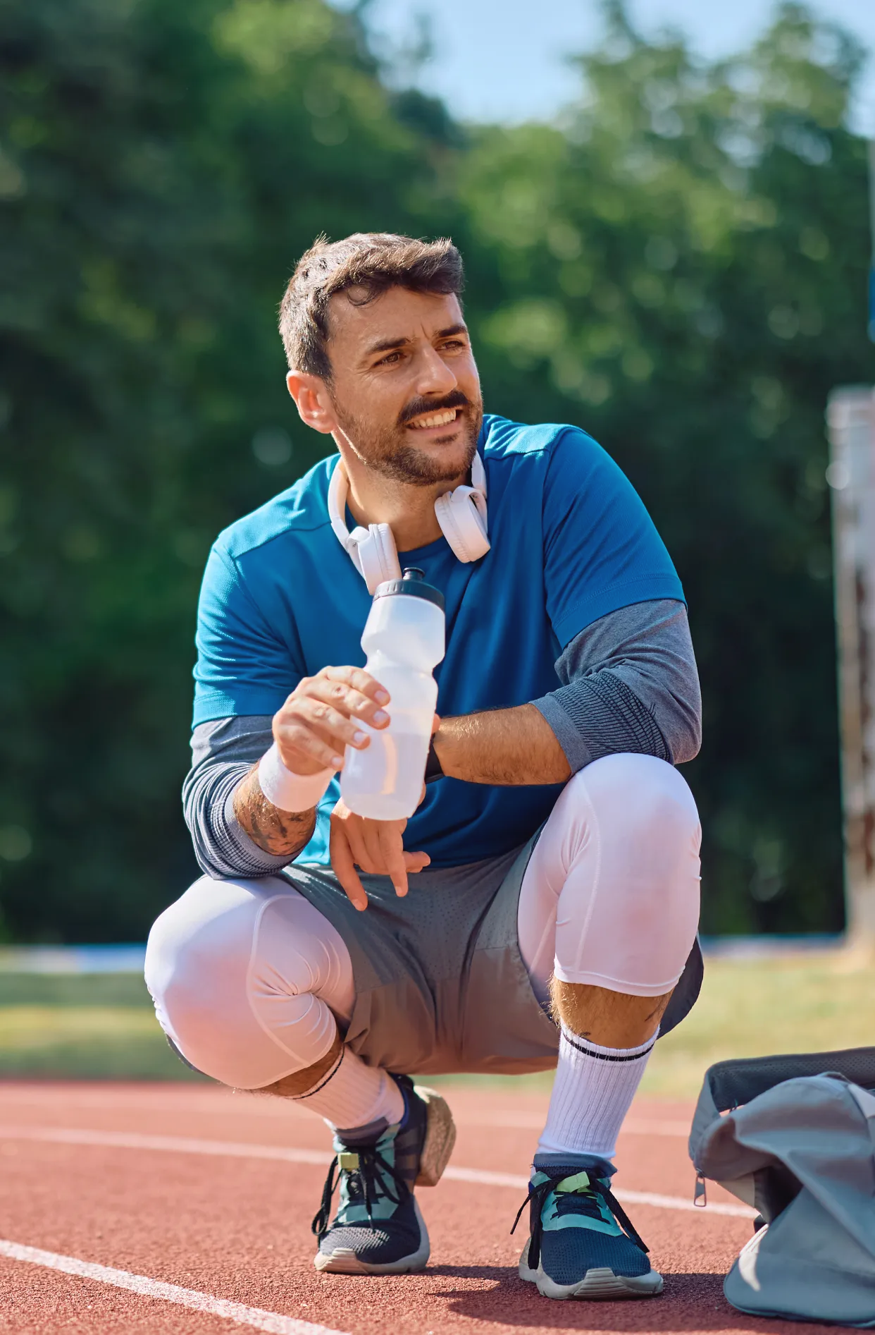 happy athlete having water break on a running trac utc