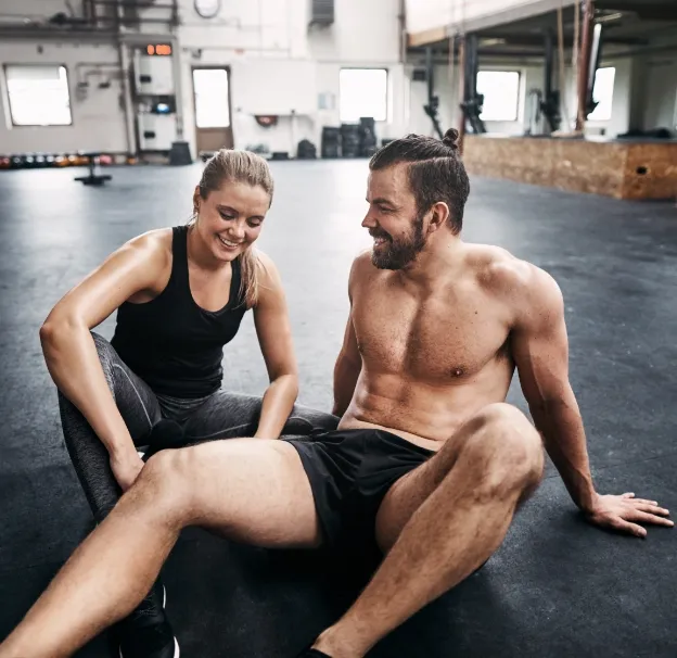 two people resting resting on a gym floor after ex utc