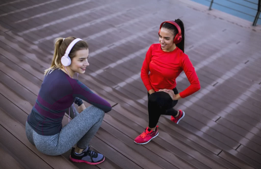 two young women doing gymnastic exercises outdoor utc