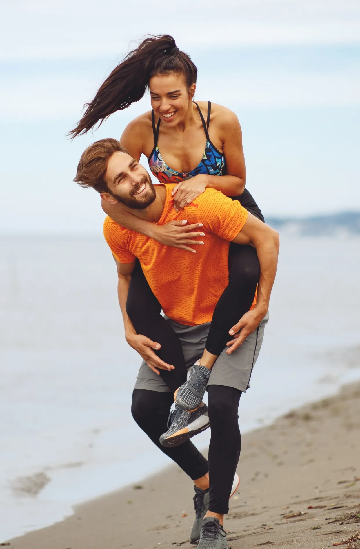 young couple enjoying the beach after workout utc